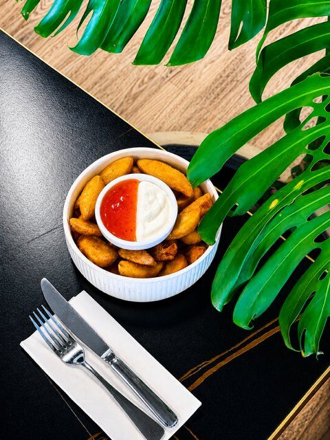 Crunchy seasoned potato wedges with coconut cream and sweet chilli sauce